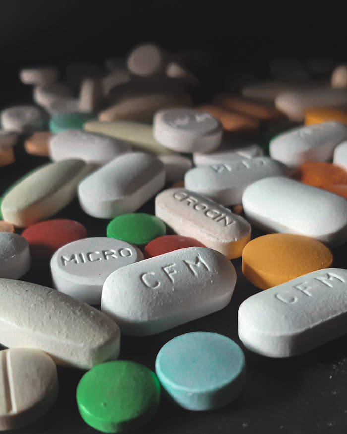 Close-up of various colored pills and tablets scattered on a surface, showcasing diversity in medicine.